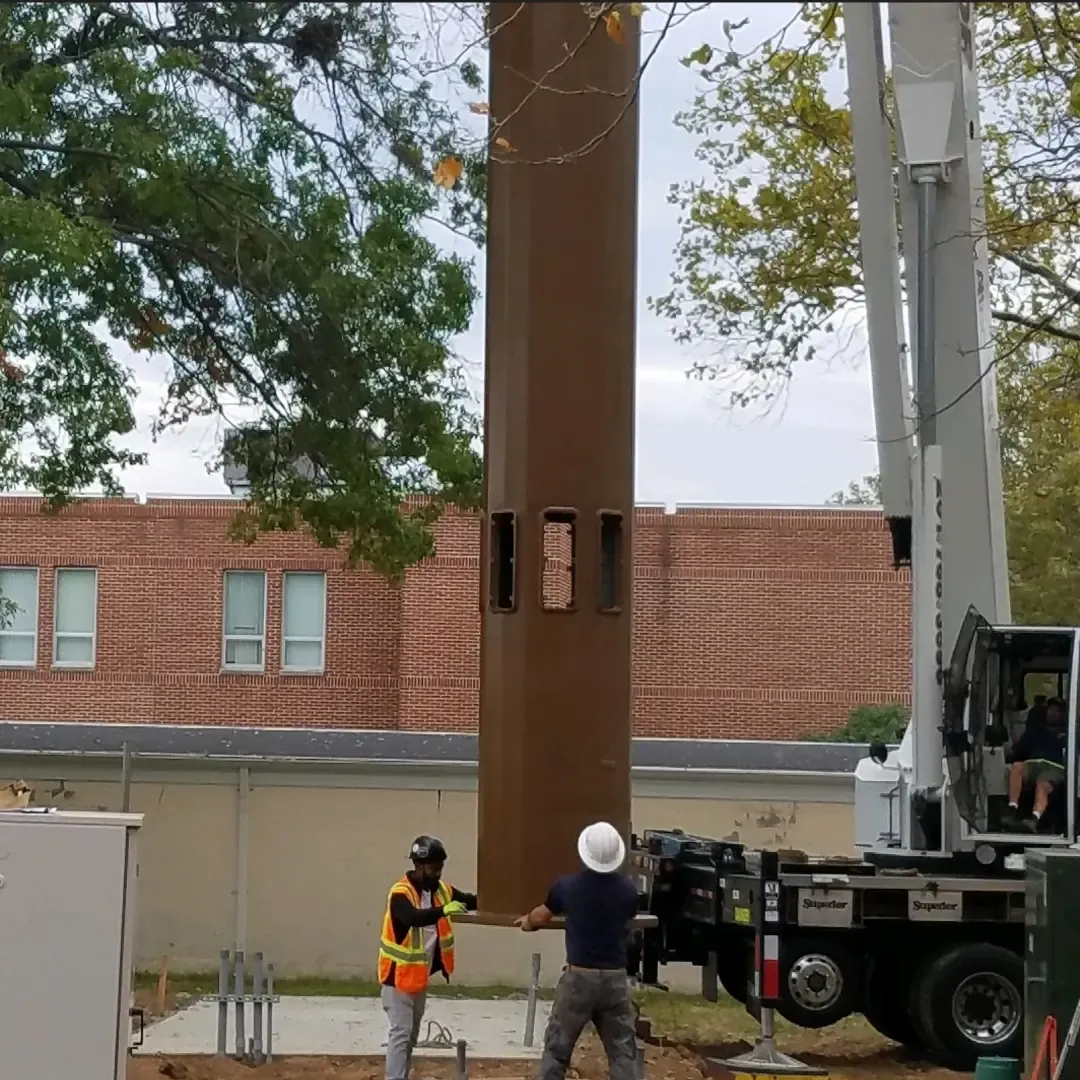 Crew setting a monopole with a crane